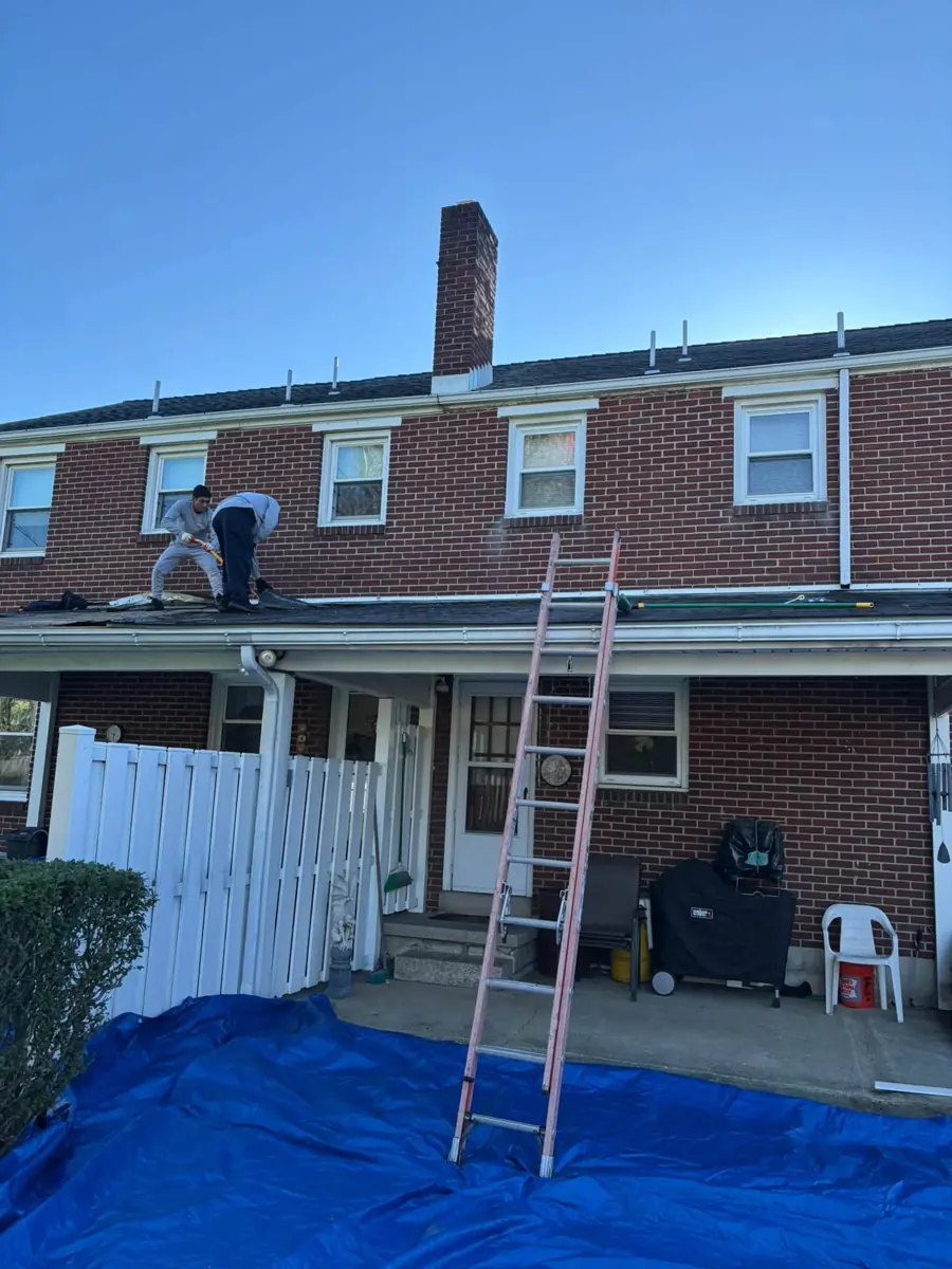 Ted's crew on the roof of a brick colonial with tarps below
